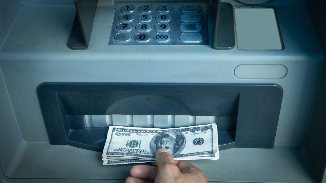 Hand holding dollars withdrawn from ATM