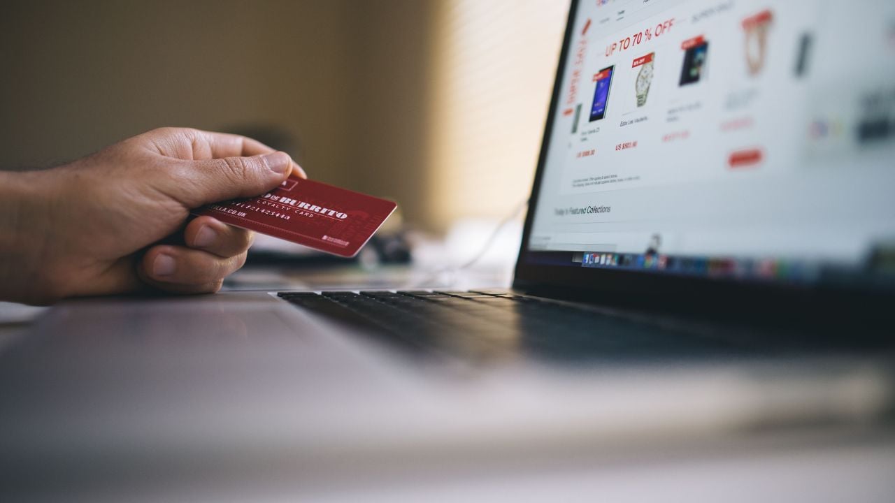 A person holding a credit card shopping online on Amazon