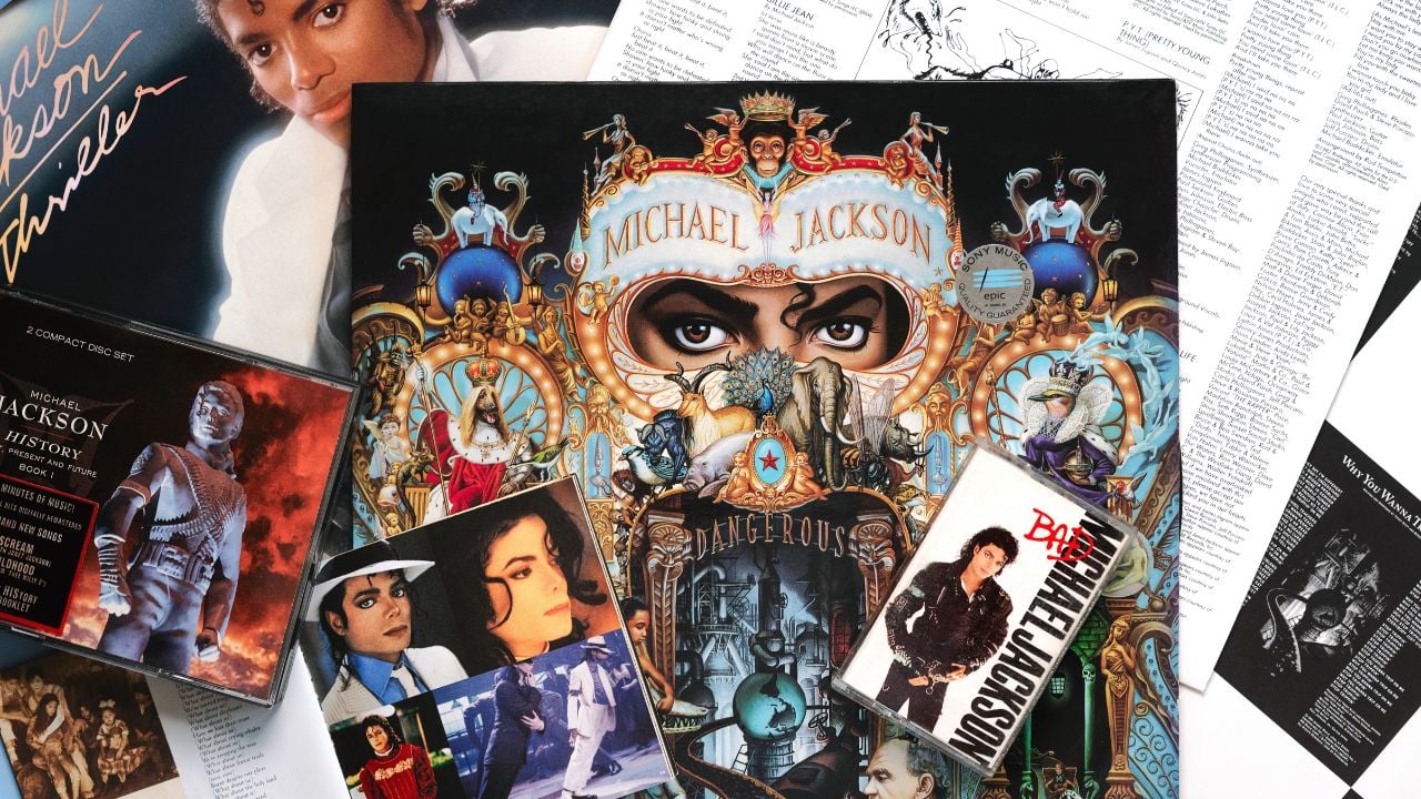 Close up of vinyl lp Dangerous of Michael Jackson,cds and audio cassette tape over blue background.