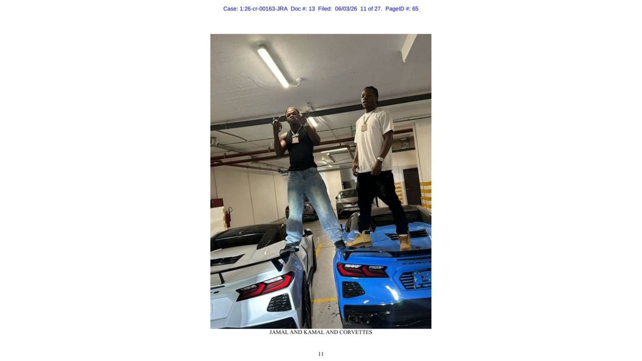 Two men posing on white and blue Chevrolet Corvettes in a photograph submitted by federal prosecutors.