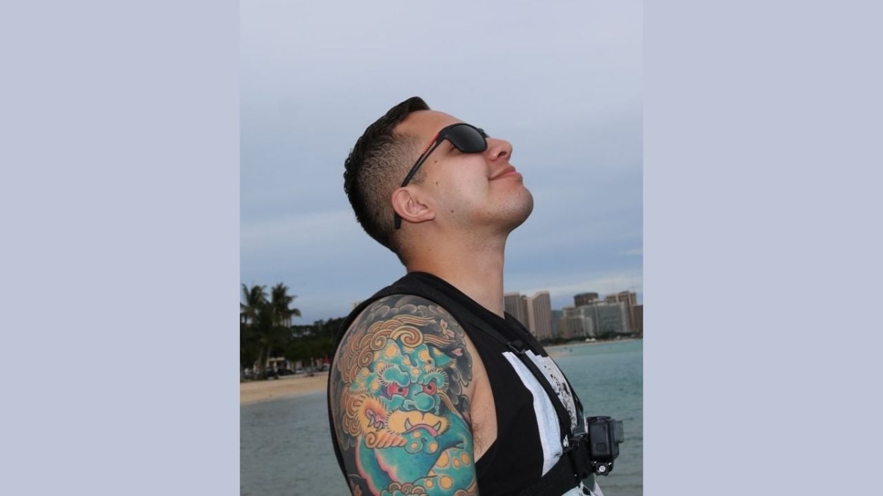 FBI-published side-view photograph of Imer Gomez wearing sunglasses and a sleeveless top outdoors.