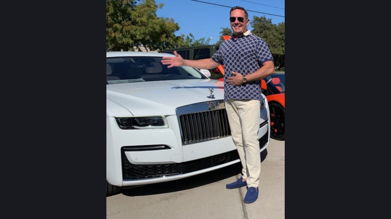Duncan John MacDonald standing beside a white Rolls-Royce Ghost.